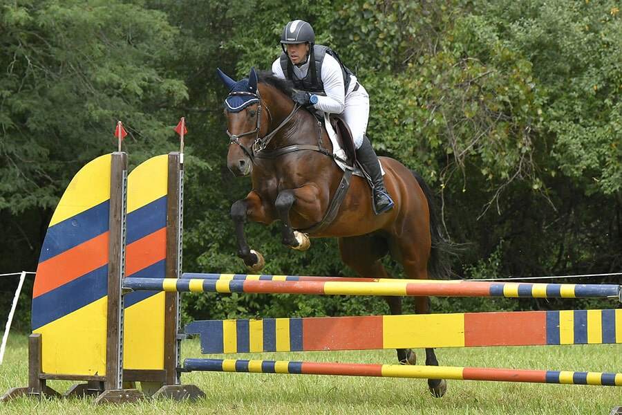 Fernhill Melody jumping yellow oxer on grass