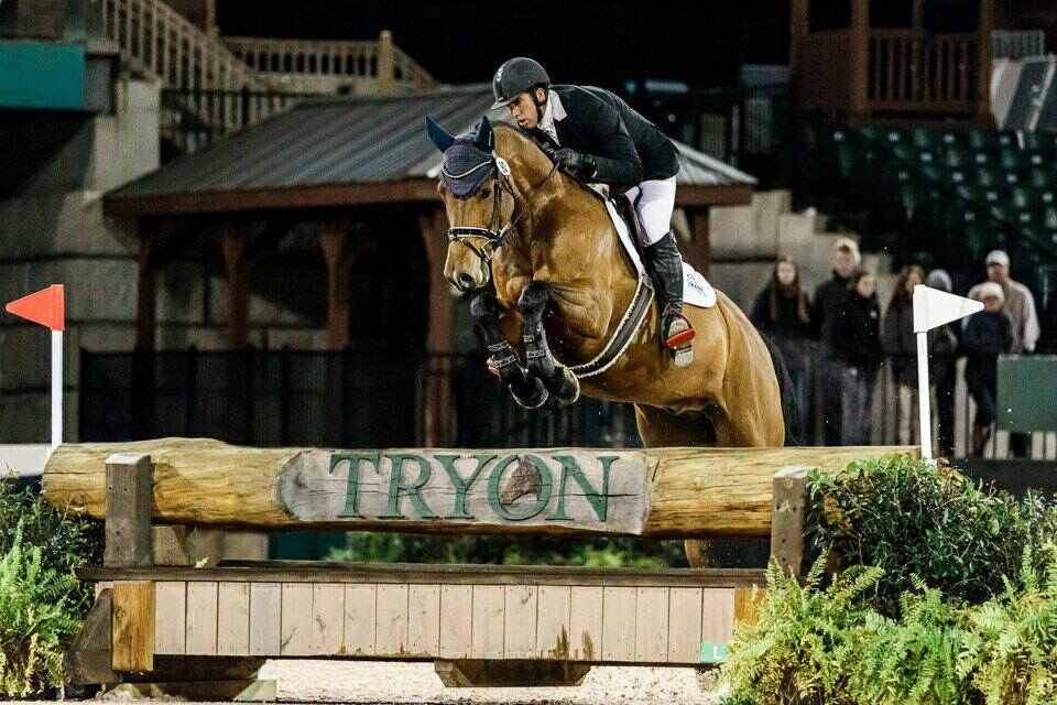 horse jumping log fence at tryon